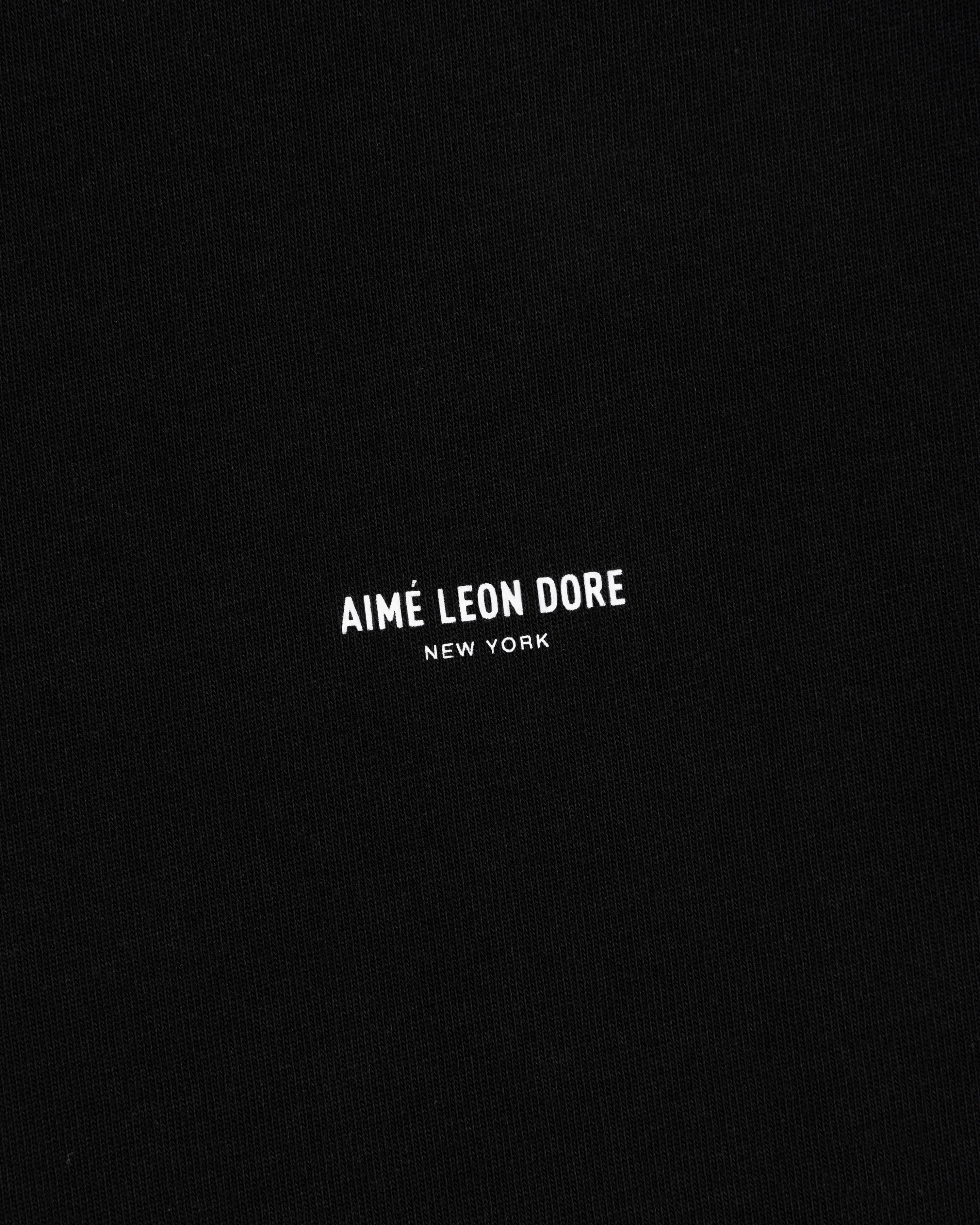 Long-Sleeve Micro Logo Tee in black with “AIMÉ LEON DORE NEW YORK” printed in small white capitals at center.