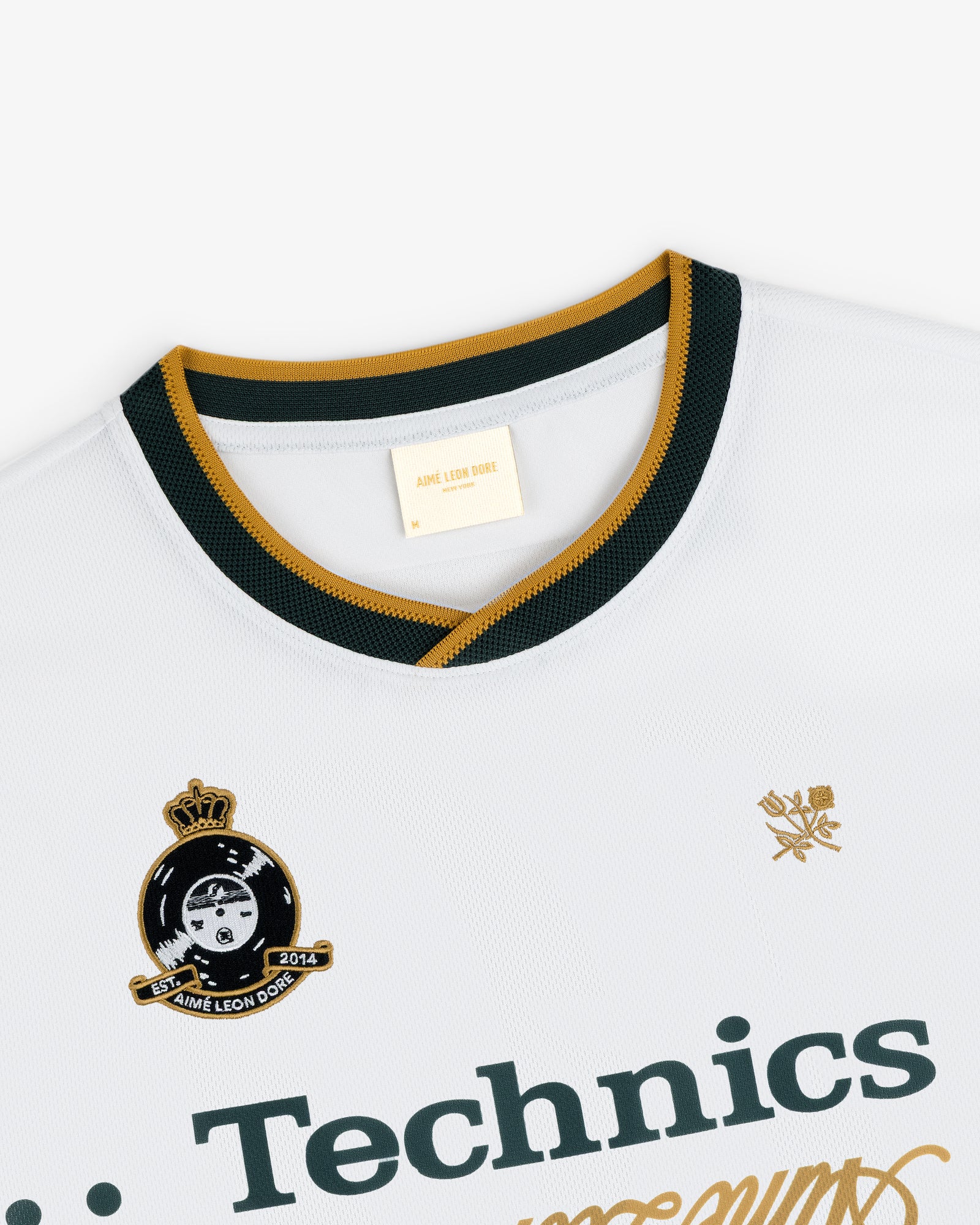 ALD / Technics Soccer Jersey: white with green and gold collar, Technics logo, and Aimé Leon Dore crest on chest.