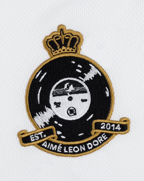 A black vinyl record crest with a gold crown and EST. 2014 AIMÉ LEON DORE on the ALD / Technics Soccer Jersey.