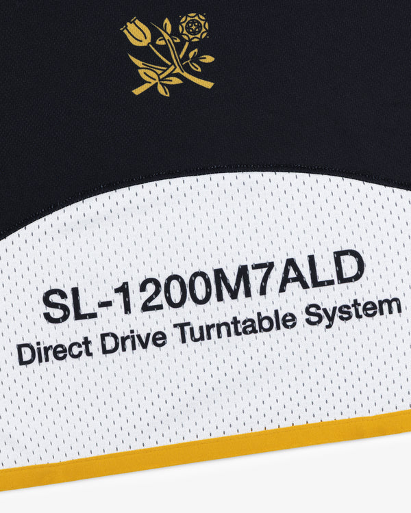 Close-up of text on an ALD / Technics Soccer Jersey with a yellow rose graphic above.