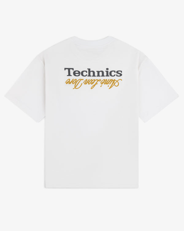 The ALD / Technics Logo Tee is a white T-shirt with "Technics" and "Online Team One" upside down on the back in black and gold.