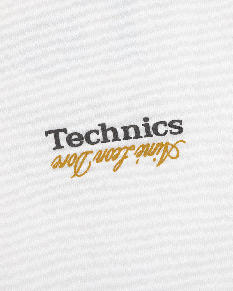 ALD / Technics Logo Tee: White fabric with black "Technics" and gold "active floor long" printed upside down.