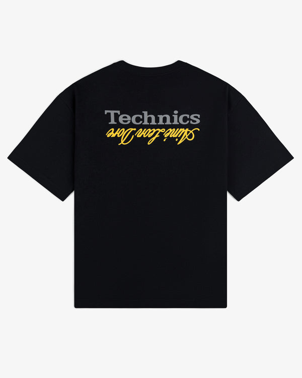 ALD / Technics Logo Tee: Black tee with gray Technics and yellow Saint Léo One text, both upside down on the back.