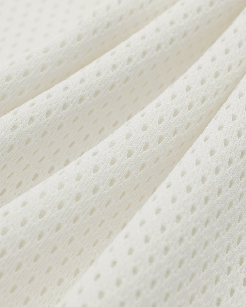 Close-up of the Mesh Batting Practice Jersey's white, breathable, perforated fabric with a textured mesh pattern.