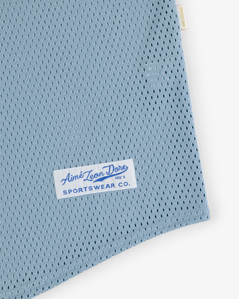 Close-up of Mesh Batting Practice Jersey in light blue mesh with a white Aimé Leon Dore Sportswear Co. label.