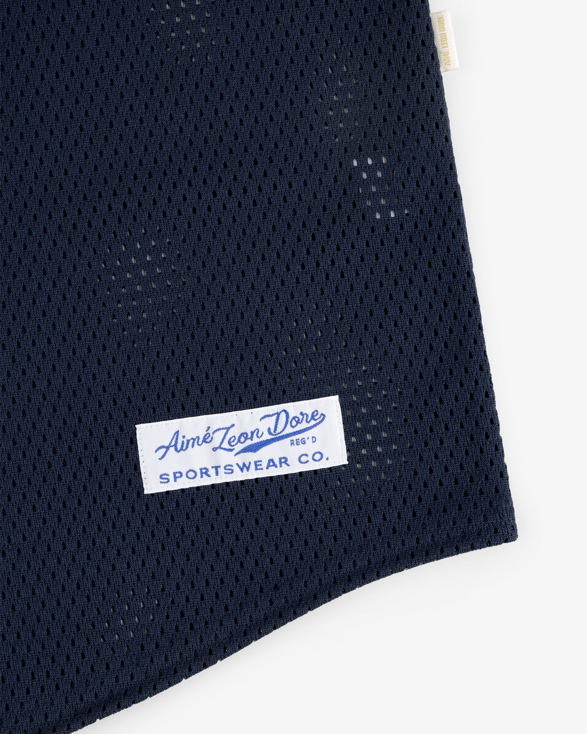 Close-up of a navy Mesh Batting Practice Jersey with an Aimé Leon Dore Sportswear Co. label sewn on.