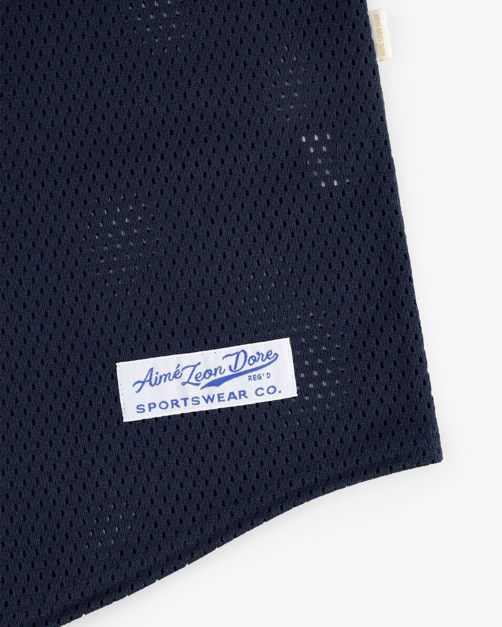Close-up of a navy Mesh Batting Practice Jersey with an Aimé Leon Dore Sportswear Co. label sewn on.