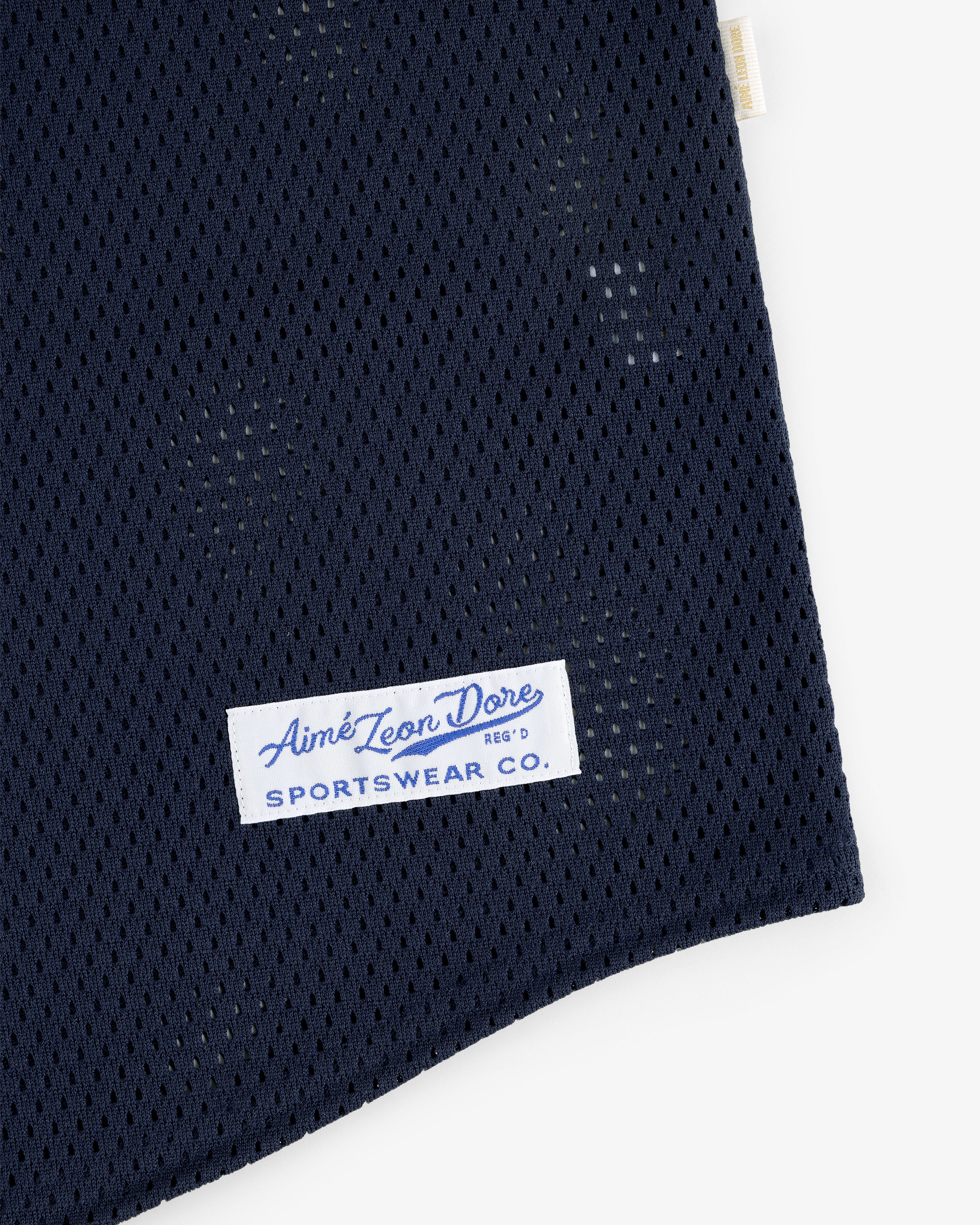 Close-up of a navy Mesh Batting Practice Jersey with an Aimé Leon Dore Sportswear Co. label sewn on.