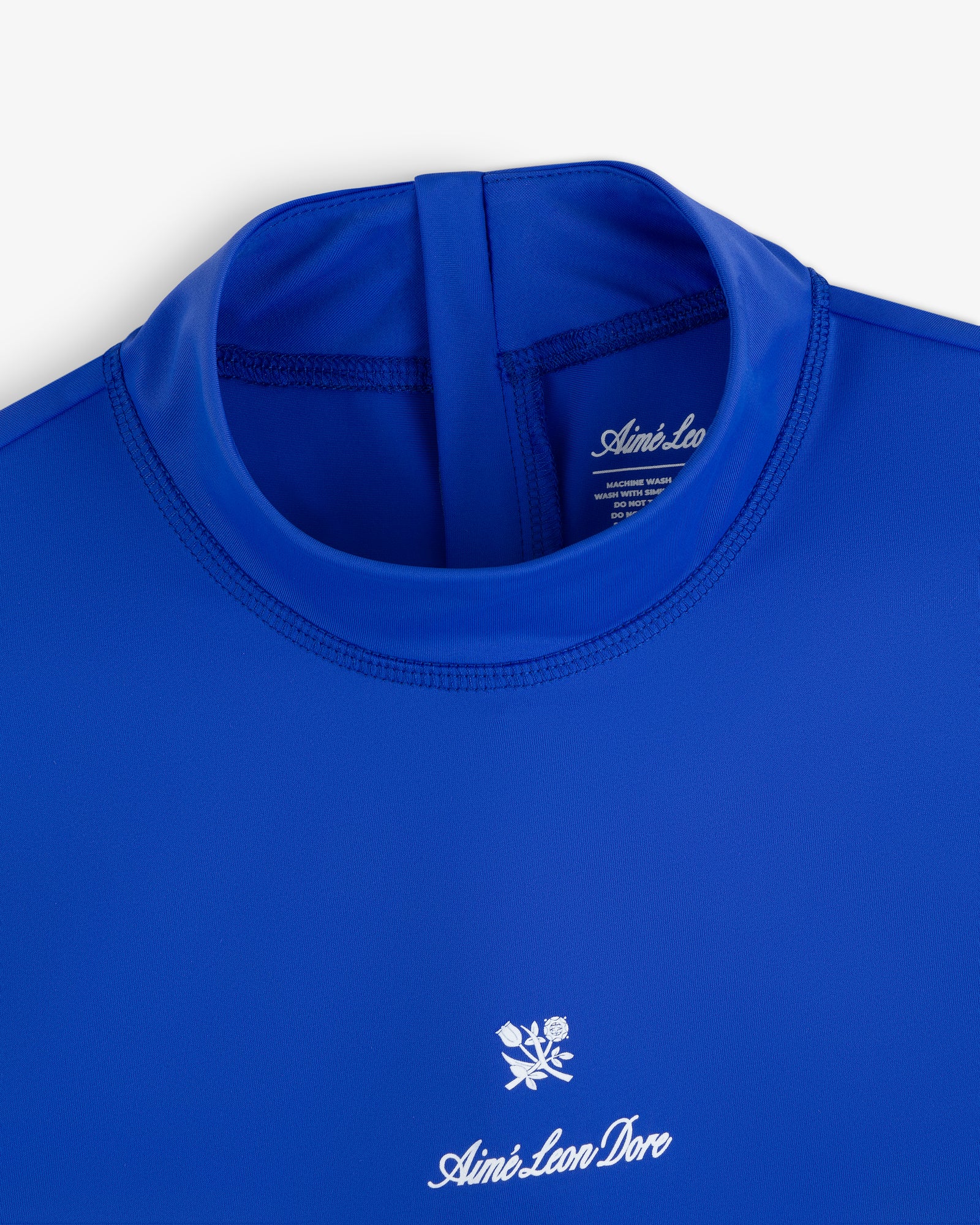 Blue Short Sleeve Crest Rash Guard with “Aimé Leon Dore” and a small white rose logo embroidered on the chest.