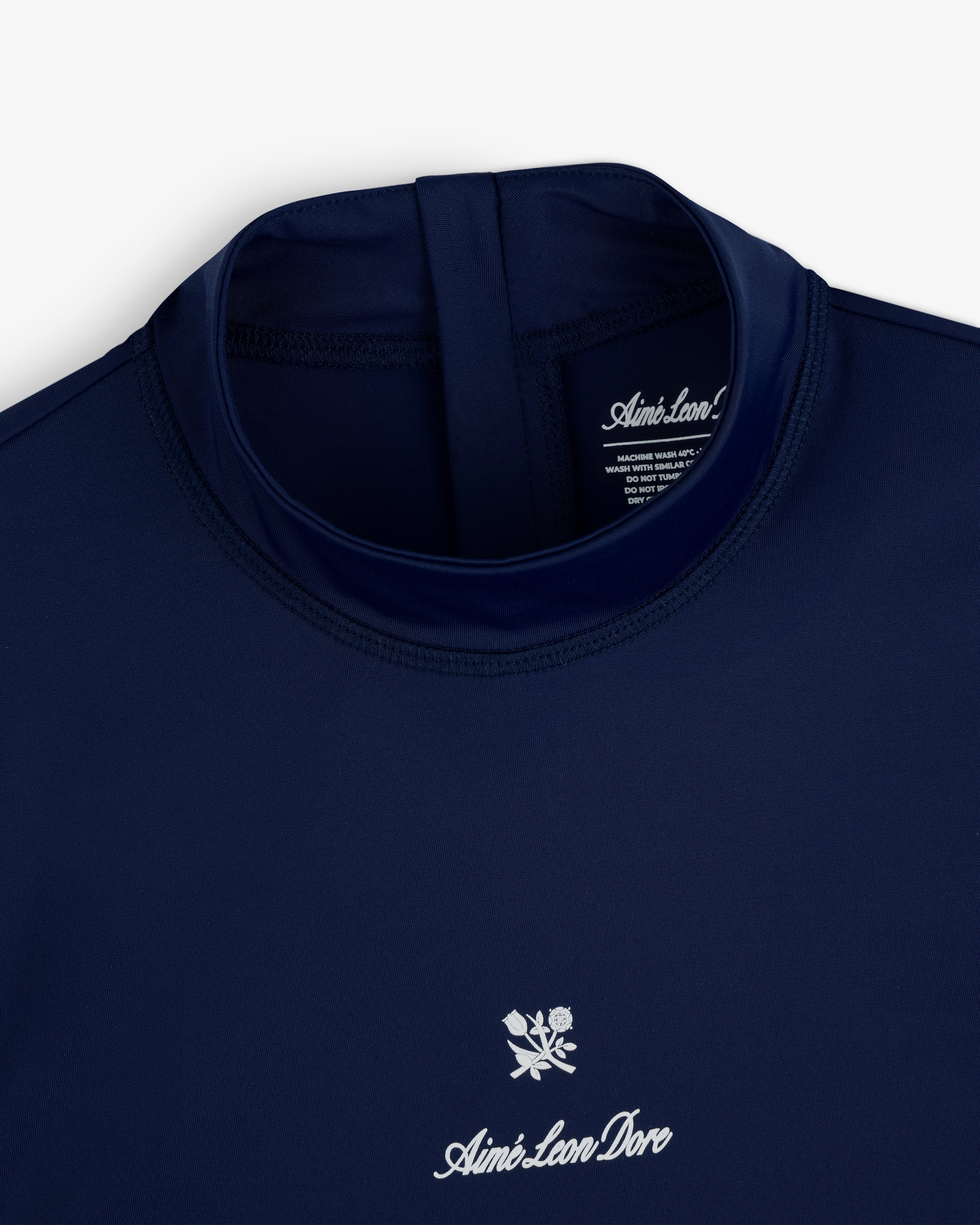 Navy blue Aimé Leon Dore Short Sleeve Crest Rash Guard with white logo and floral chest design, collar down view.