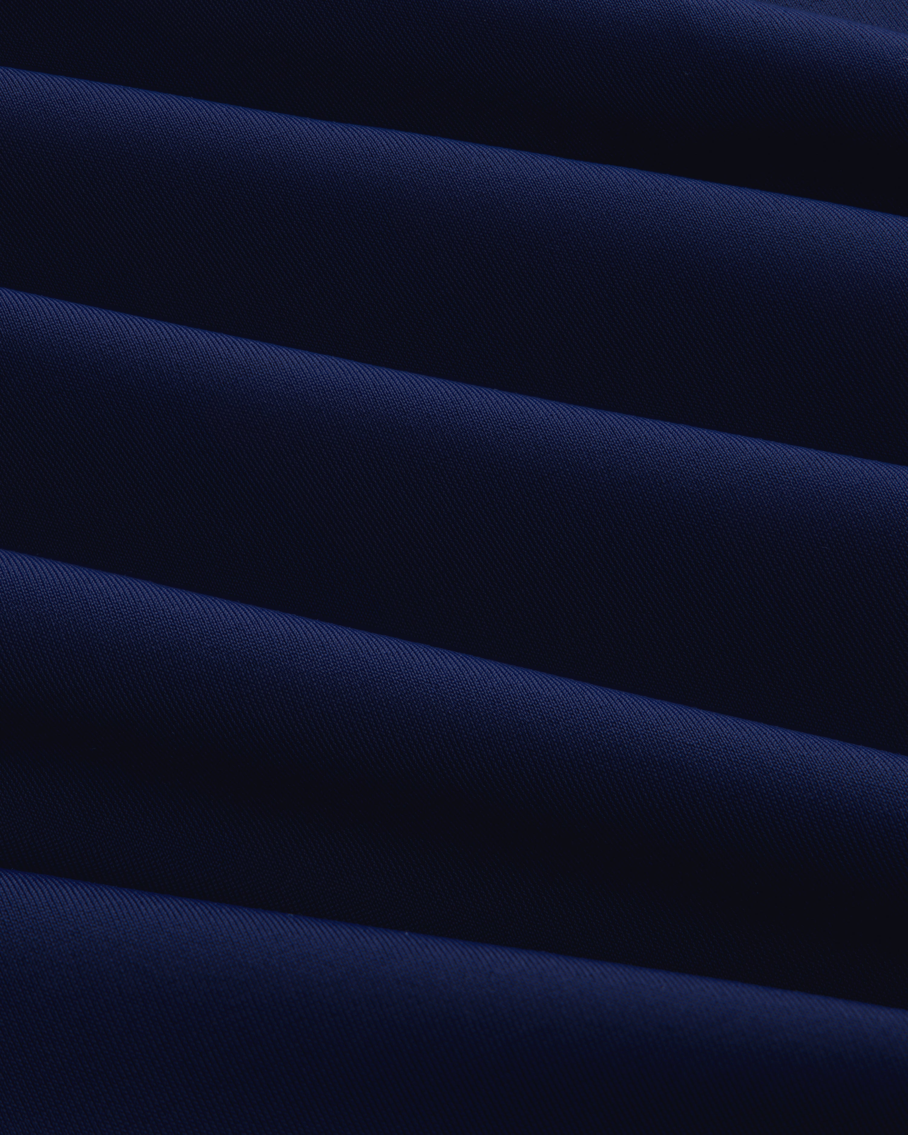 Close-up of the Short Sleeve Crest Rash Guard, showing folded dark blue fabric with ridged, diagonal texture.