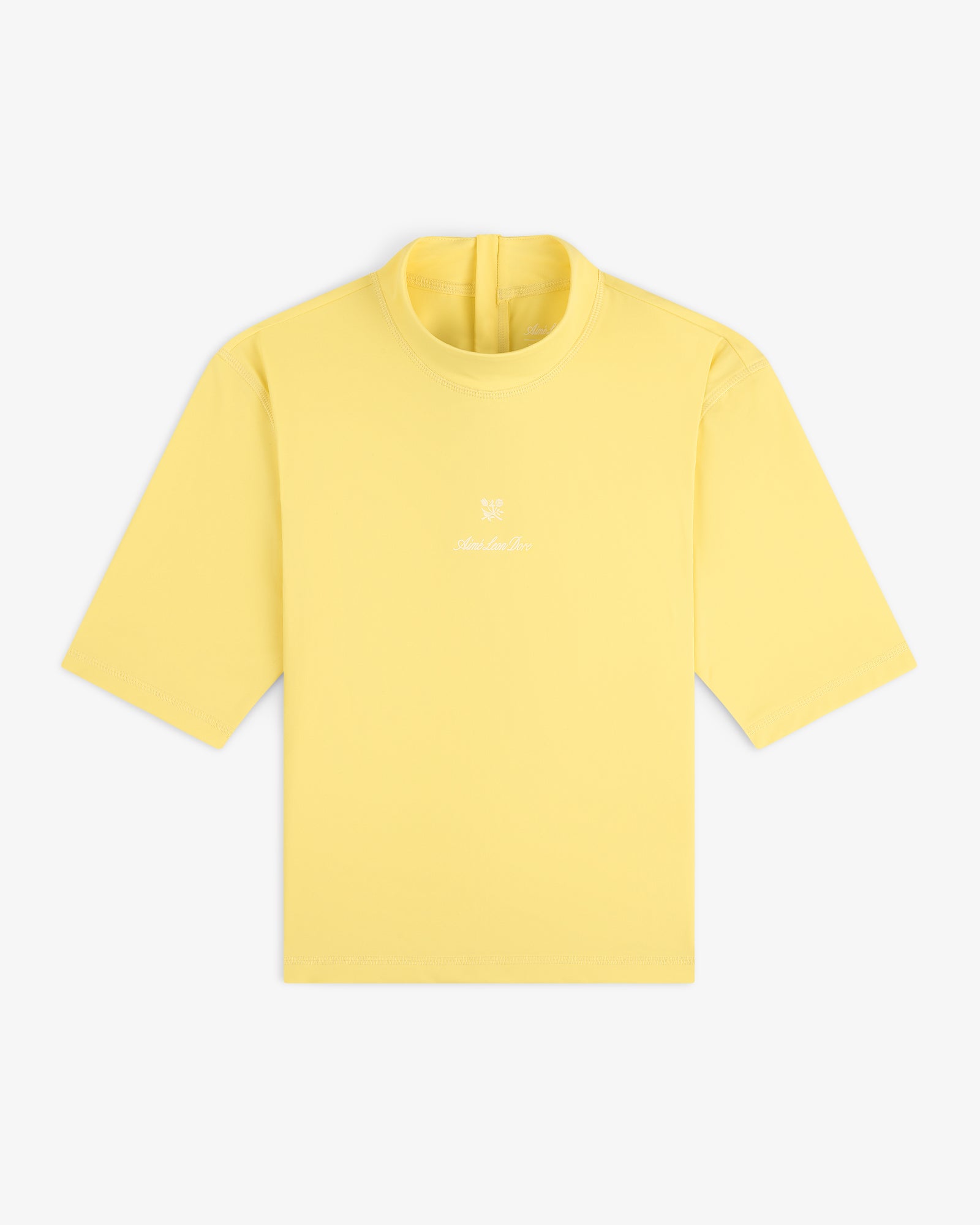 A yellow Short Sleeve Crest Rash Guard with a small white logo and text on the chest, laid flat on a white background.