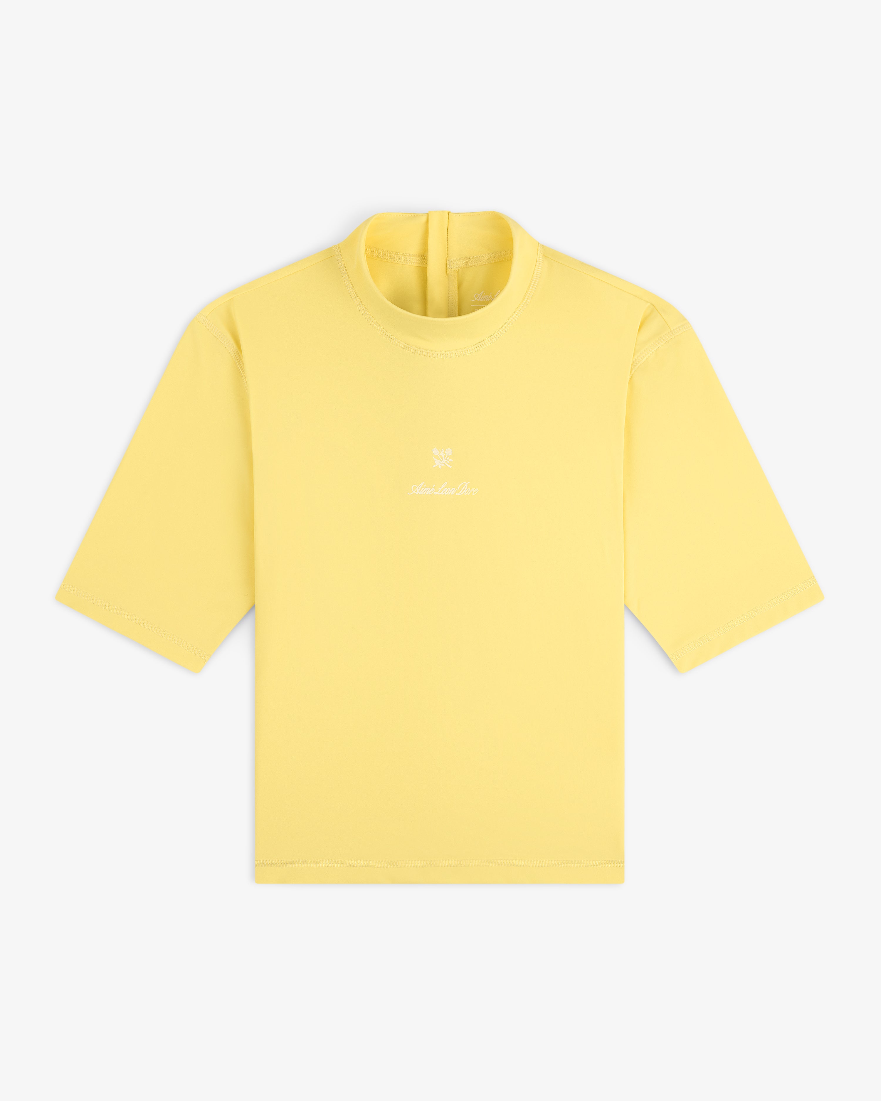 A yellow Short Sleeve Crest Rash Guard with a small white logo and text on the chest, laid flat on a white background.