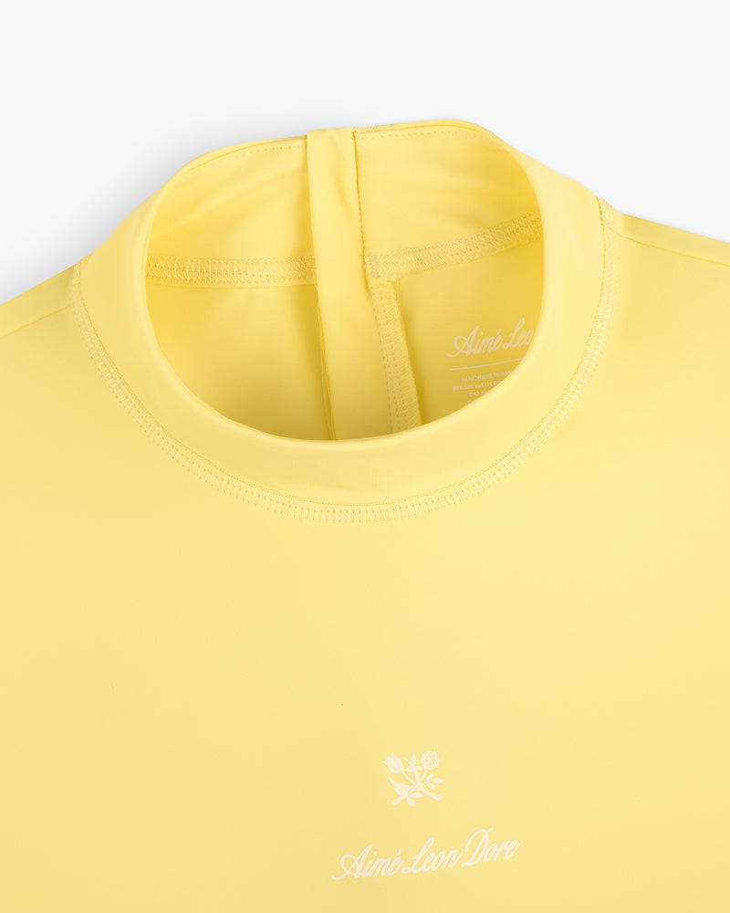 Yellow Short Sleeve Crest Rash Guard with Aimé Leon Dore and small white flower logo on the chest.