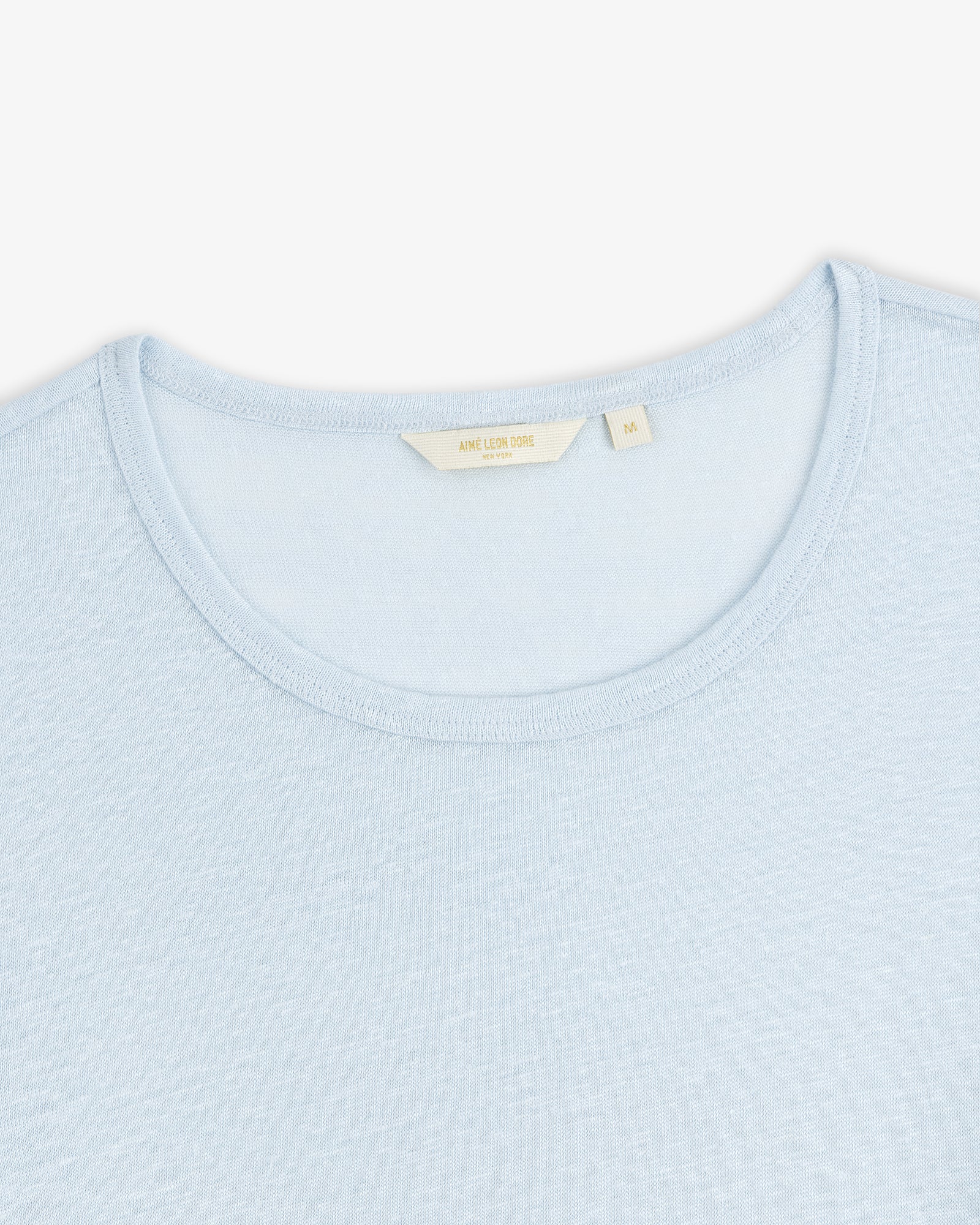 Light blue Linen Tee with a visible beige collar tag, displayed on a white background.