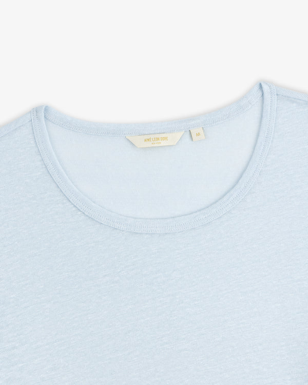 Light blue Linen Tee with a visible beige collar tag, displayed on a white background.