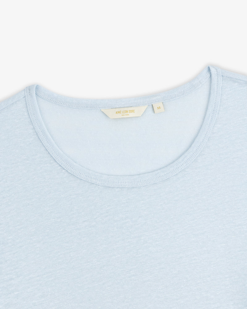 Light blue Linen Tee with a visible beige collar tag, displayed on a white background.