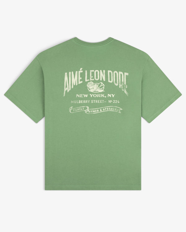 Neighborhood Pocket Tee featuring “AIMÉ LEON DORE New York, NY Mulberry Street” and white back graphic.