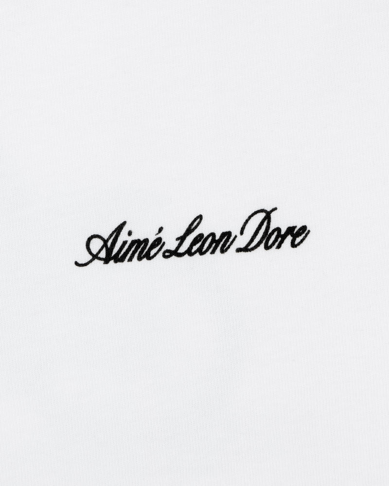 Black script text Aimé Leon Dore is embroidered on the white Super Cub Tee.