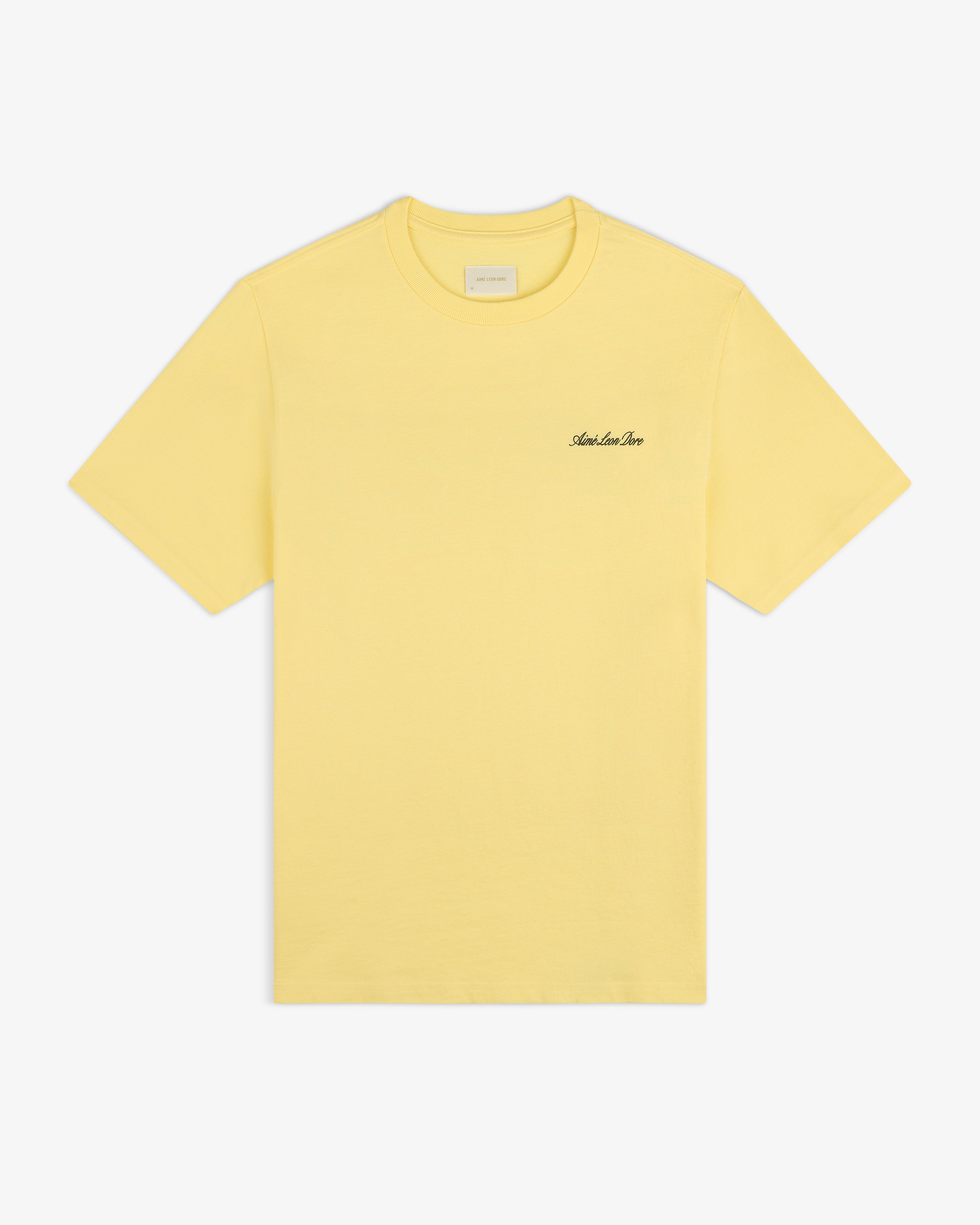 Super Cub Tee: yellow short-sleeve shirt with small black cursive text on the left chest, shown on white background.