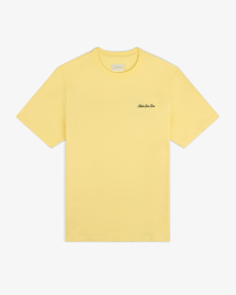 Super Cub Tee: yellow short-sleeve shirt with small black cursive text on the left chest, shown on white background.