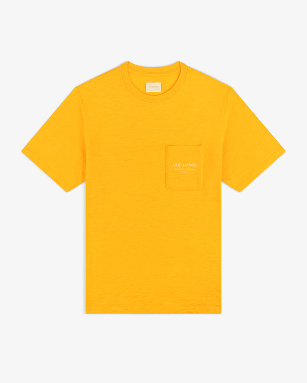 Artiste Pocket Tee: bright yellow short-sleeve t-shirt with a chest pocket featuring small white text.