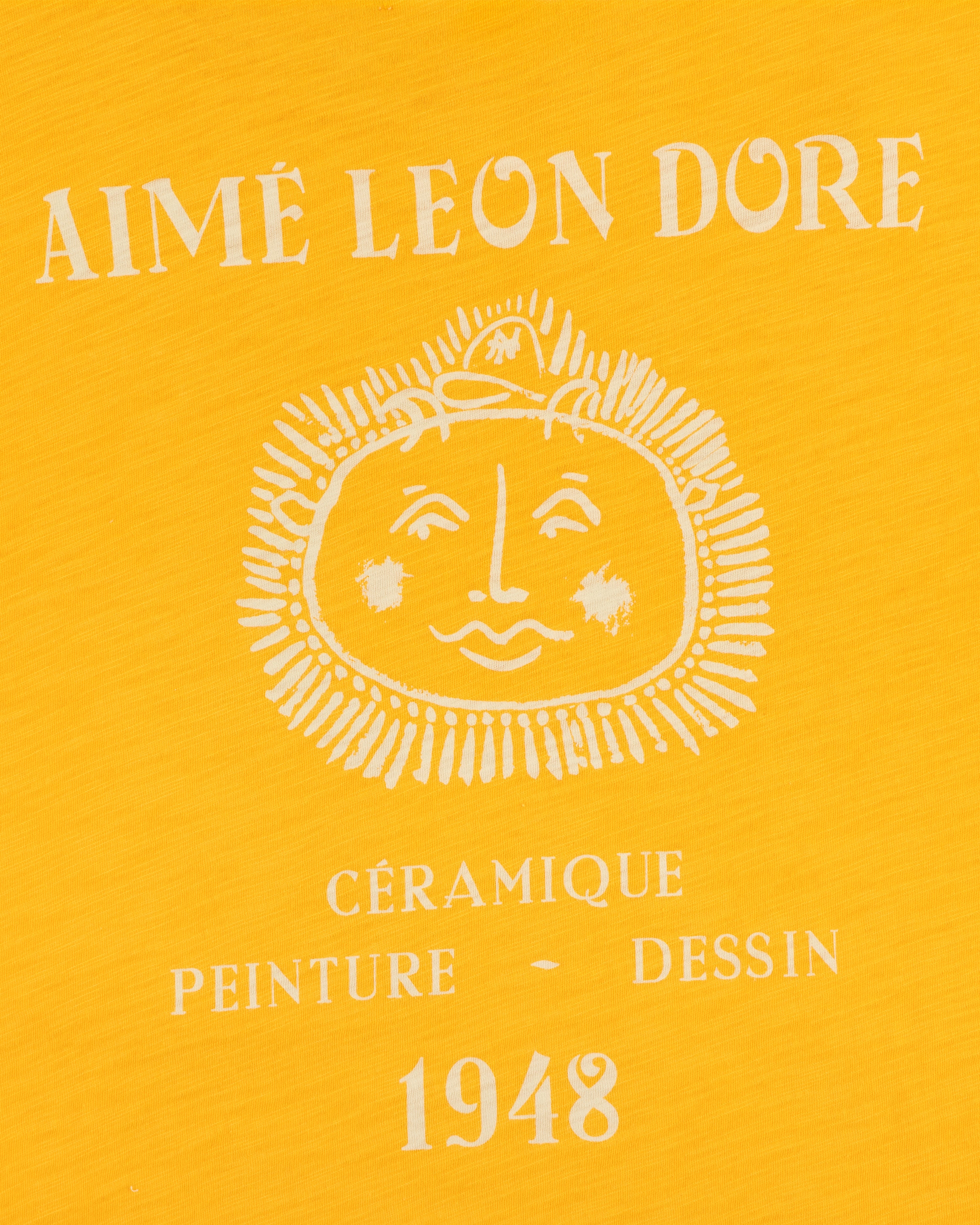 Yellow background Artiste Pocket Tee with AIMÉ LEON DORE, sun face, and CÉRAMIQUE PEINTURE DESSIN 1948 text.