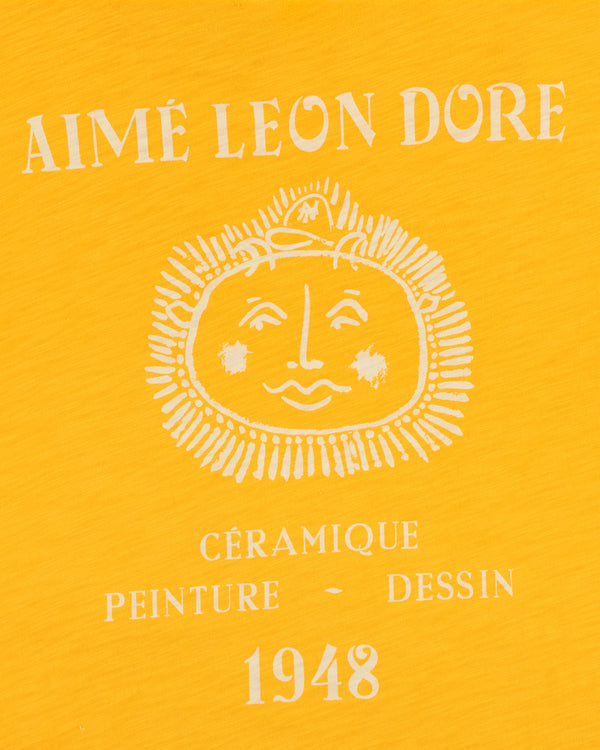 Yellow background Artiste Pocket Tee with AIMÉ LEON DORE, sun face, and CÉRAMIQUE PEINTURE DESSIN 1948 text.