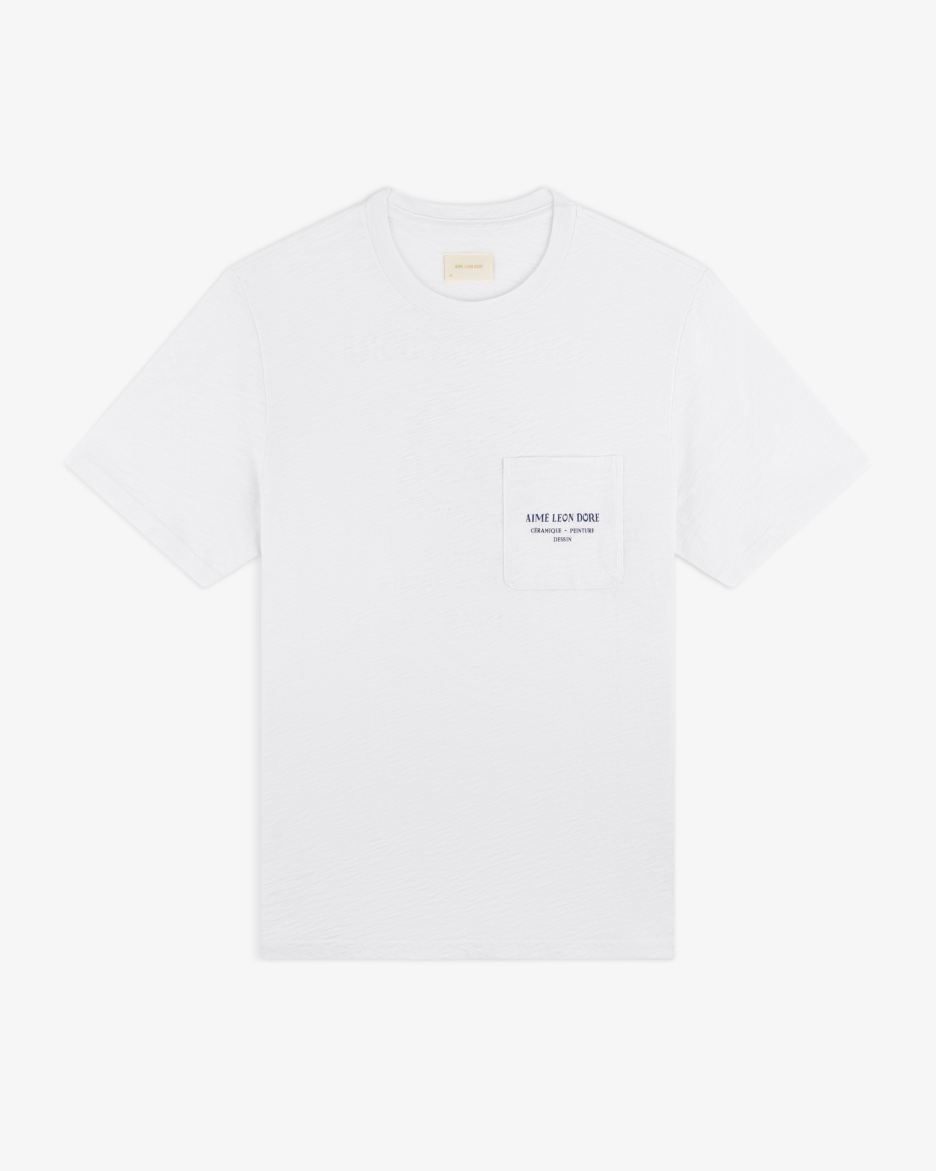 Artiste Pocket Tee: white short-sleeve t-shirt with chest pocket, small printed logo, and text.
