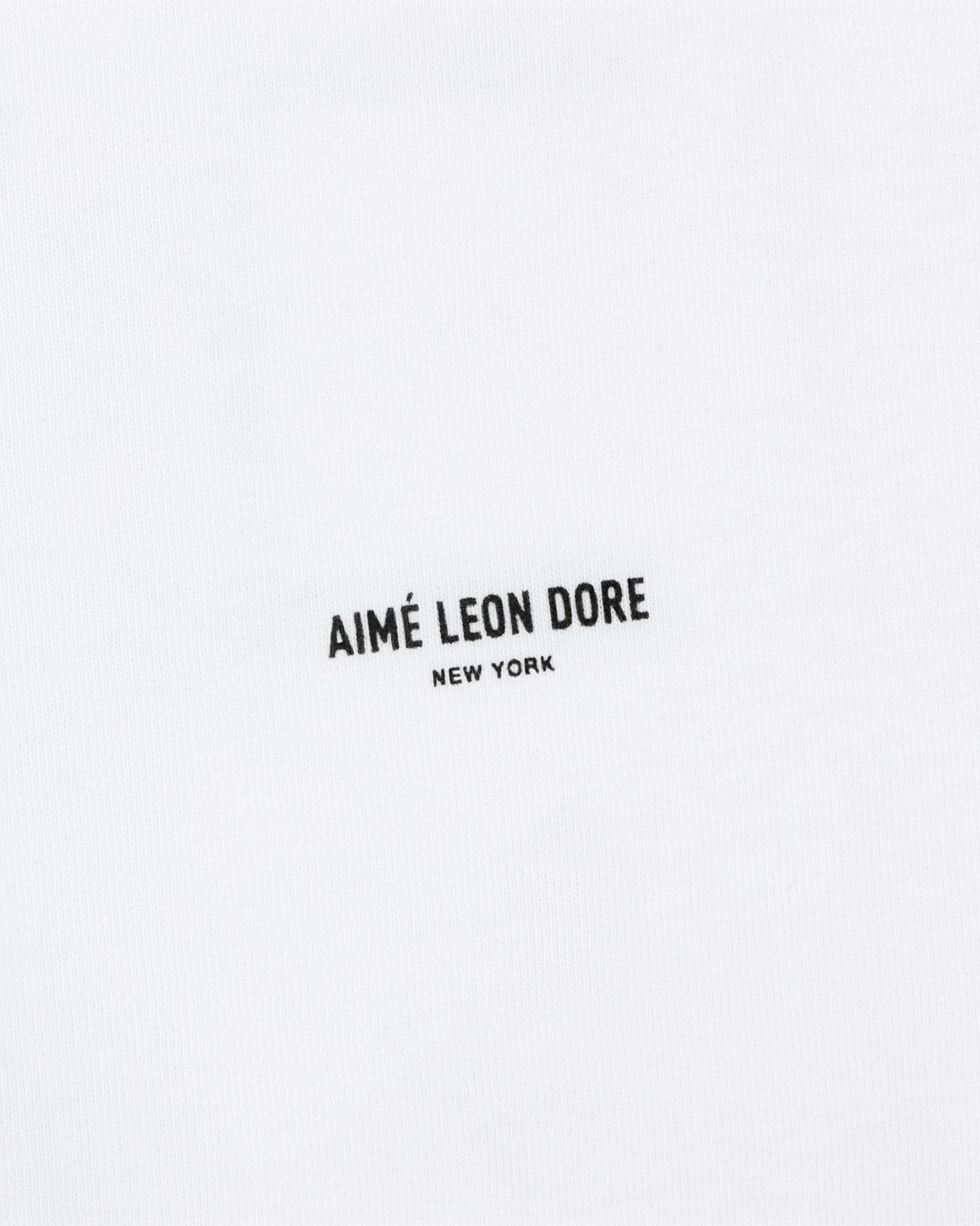 The Mott Street Tee features white fabric with "AIMÉ LEON DORE NEW YORK" printed in small black letters at the center.