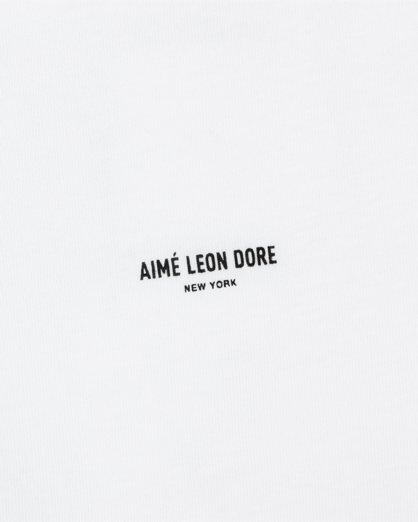The Mott Street Tee features white fabric with "AIMÉ LEON DORE NEW YORK" printed in small black letters at the center.