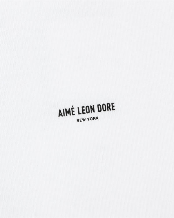 The Mott Street Tee features white fabric with "AIMÉ LEON DORE NEW YORK" printed in small black letters at the center.