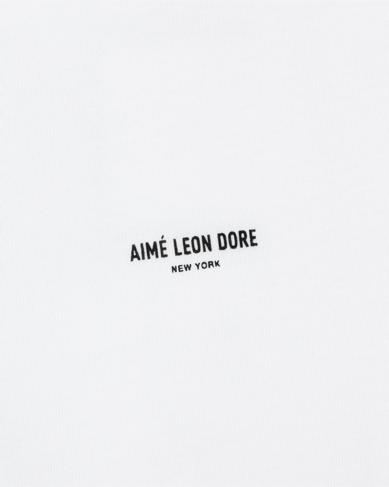 The Mott Street Tee features white fabric with "AIMÉ LEON DORE NEW YORK" printed in small black letters at the center.