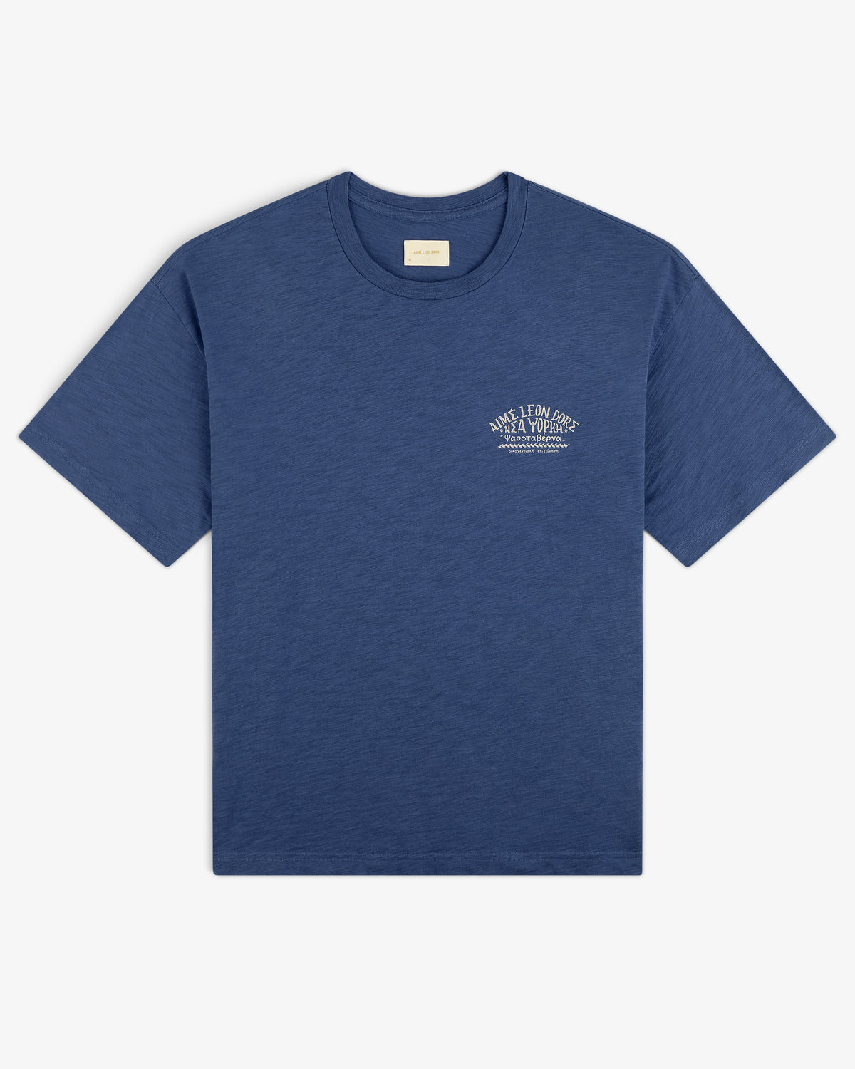 Taverna Tee: Blue short-sleeve t-shirt with small white text graphic on left chest, shown on white background.
