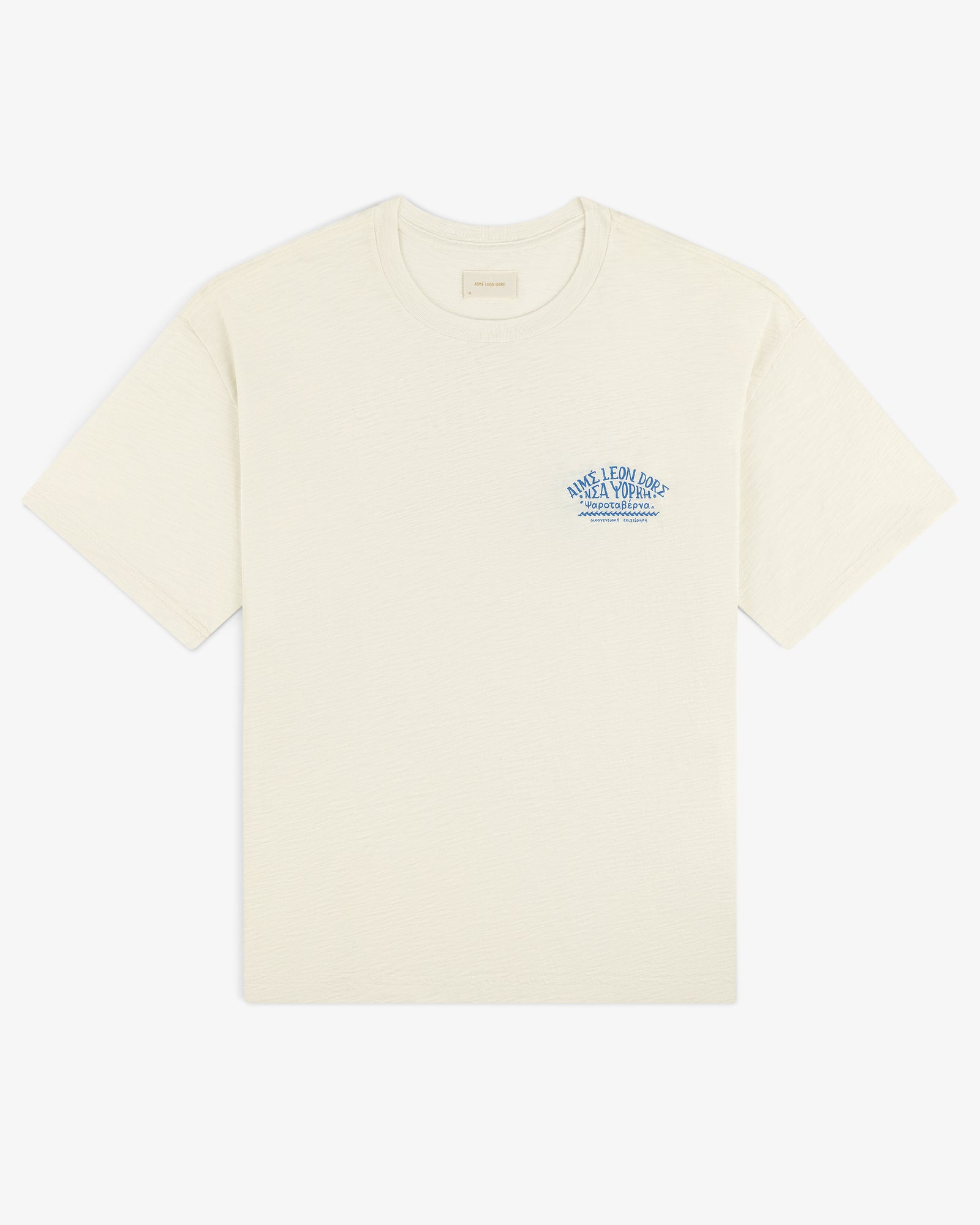 Taverna Tee: Off-white short-sleeve shirt with small blue text and graphic on the left chest.