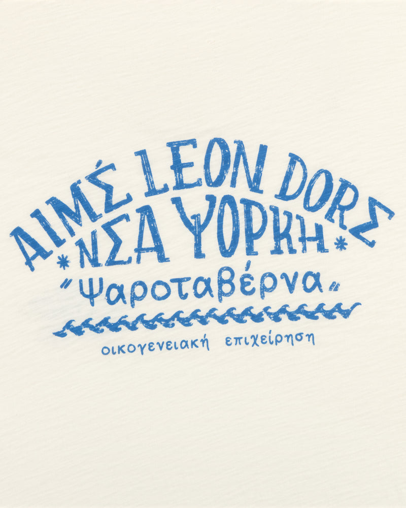 The Taverna Tee features blue Greek-style text reading Aims Leon Dore Νέα Υόρκη ‘Ψαροταβέρνα’ on a white background.