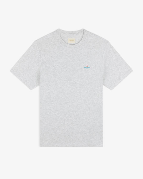 Coastal Flag Tee: light gray short-sleeve t-shirt with small embroidered logo on left chest, shown on white background.