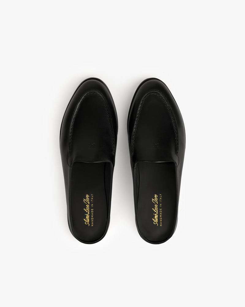 A pair of black Venetian Mule leather slip-on loafers with gold insole branding, viewed from above on white.