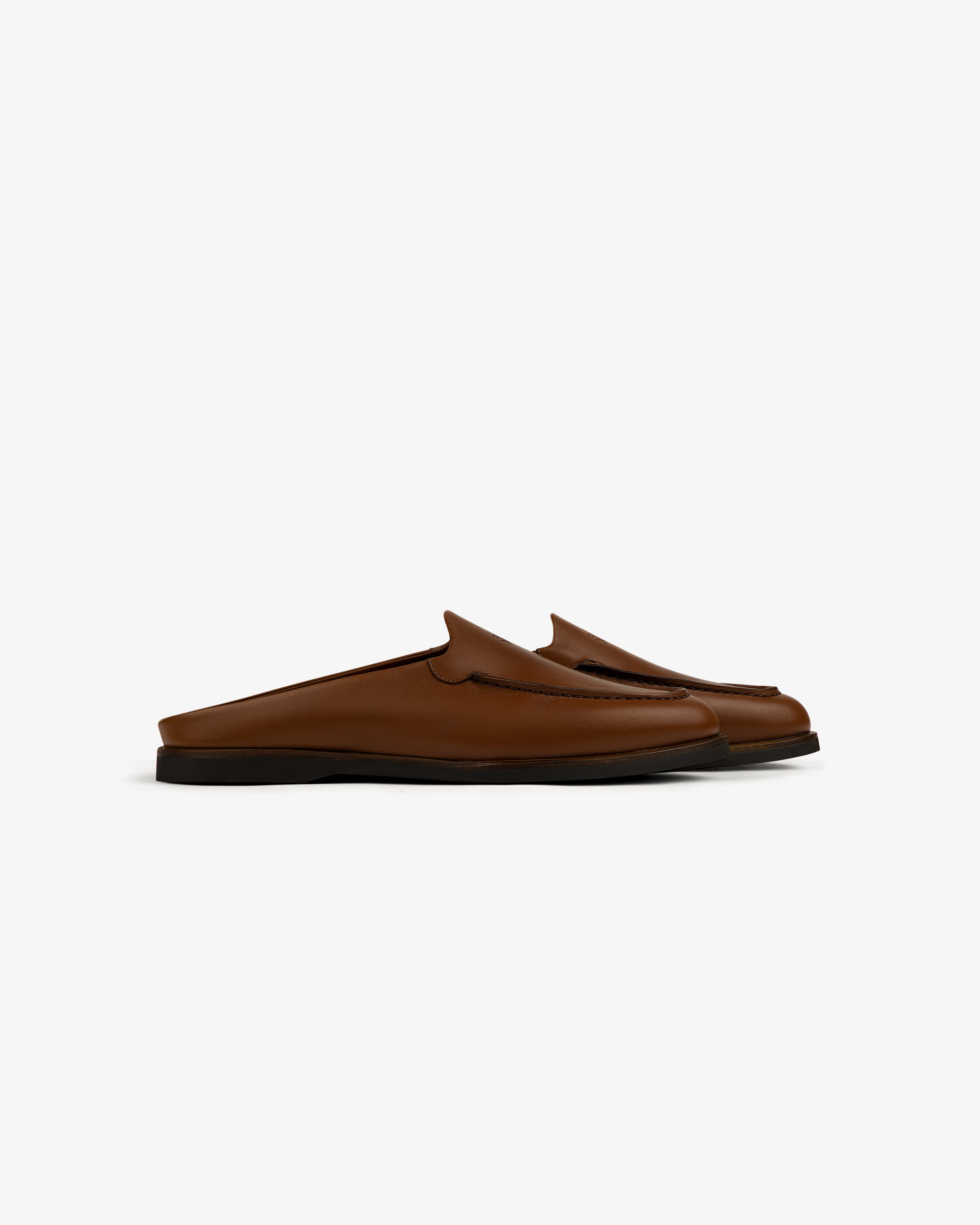 Venetian Mule brown leather slip-on loafers with black soles, backless design, side view on white background.