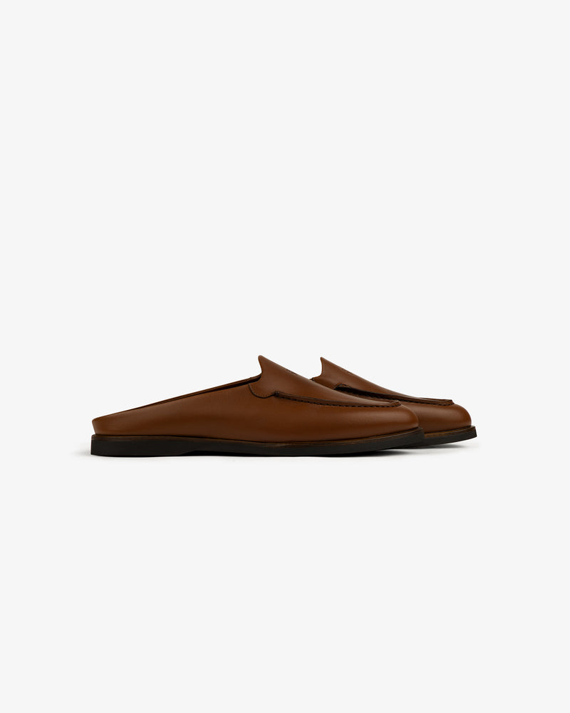 Venetian Mule brown leather slip-on loafers with black soles, backless design, side view on white background.