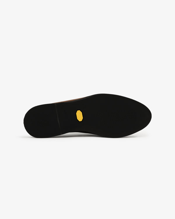 The black sole of the Venetian Mule features a small yellow hexagonal logo at its center, set against a white background.