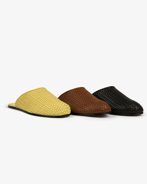 Three Leather Raffia Mules in yellow, brown, and black displayed side by side on a white background.