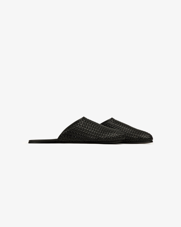 A side-profile of the Leather Raffia Mule, a black woven slip-on with pointed toes on a white background.