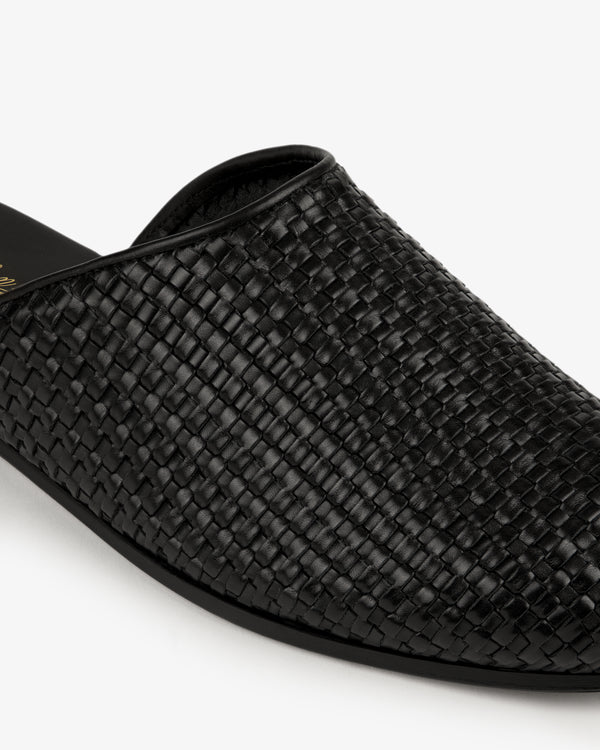 Close-up of a Leather Raffia Mule in black against a white background.