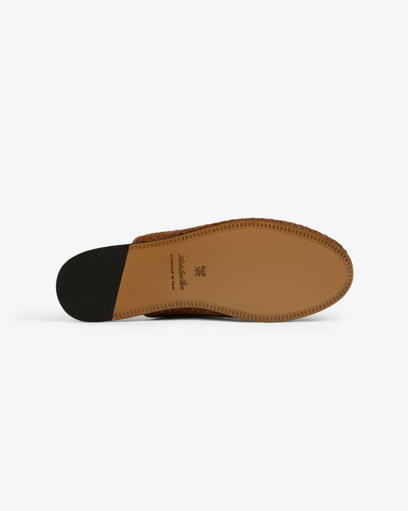 The Leather Raffia Mule features a brown sole with a tan center and black heel section seen from the bottom.