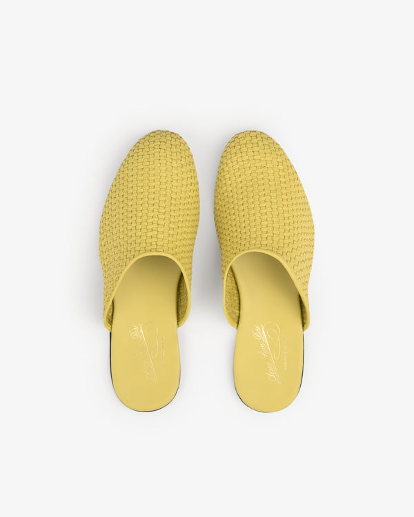A pair of Leather Raffia Mule shoes in yellow, shown from above on a white background.