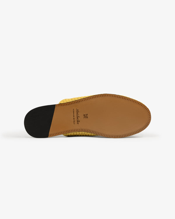 The image shows the light brown sole of the Leather Raffia Mule in yellow with a black heel, viewed from below.
