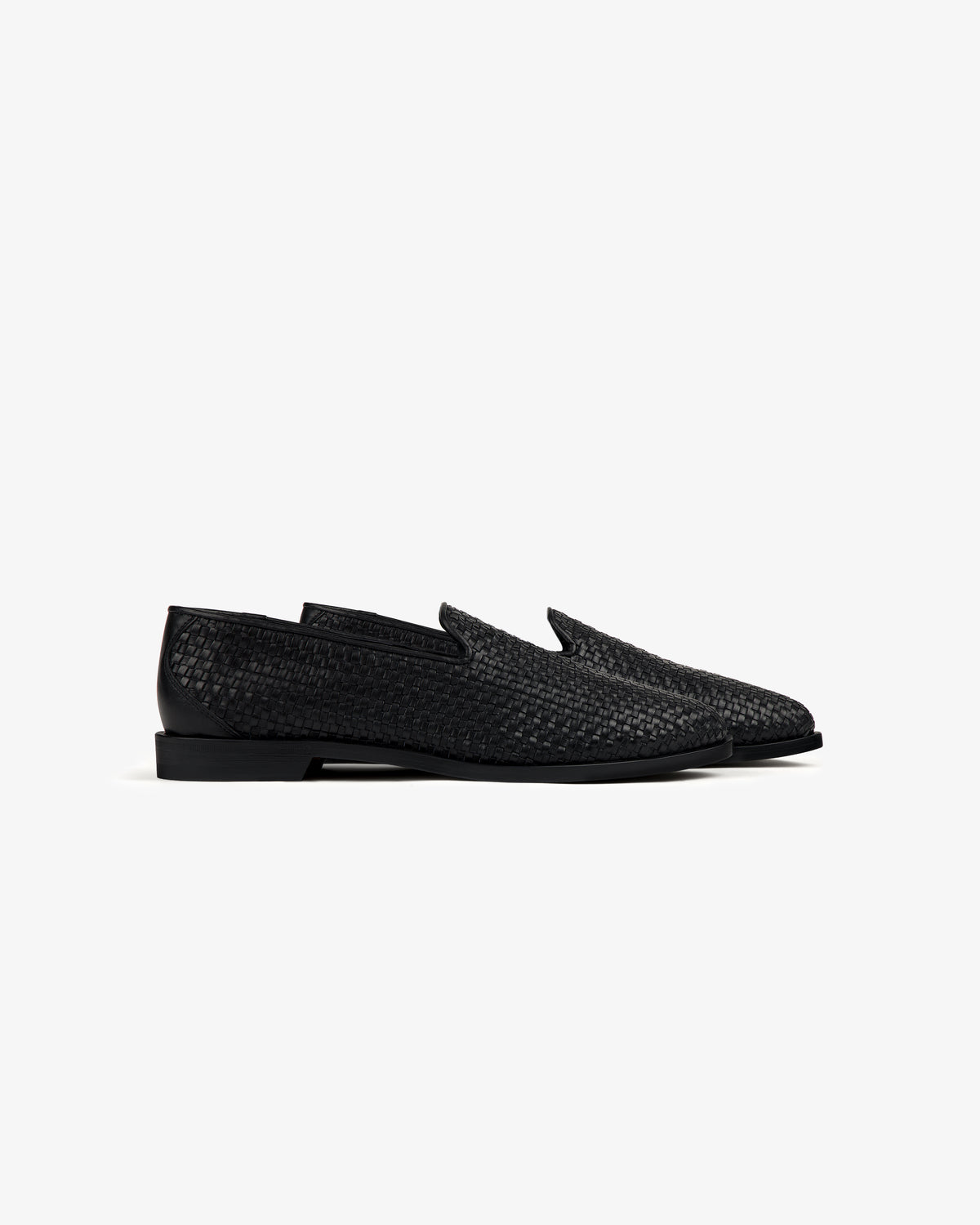 Leather Raffia Loafer in black shown in side profile, featuring woven leather and a low heel on a plain white background.