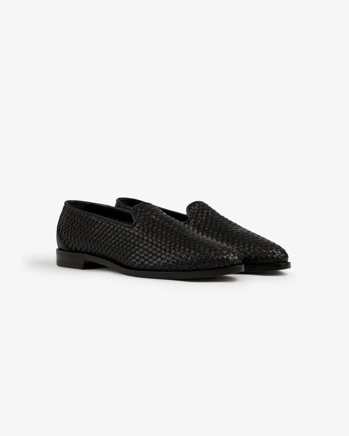 A pair of Leather Raffia Loafers in black woven leather with low heels displayed on a white background.