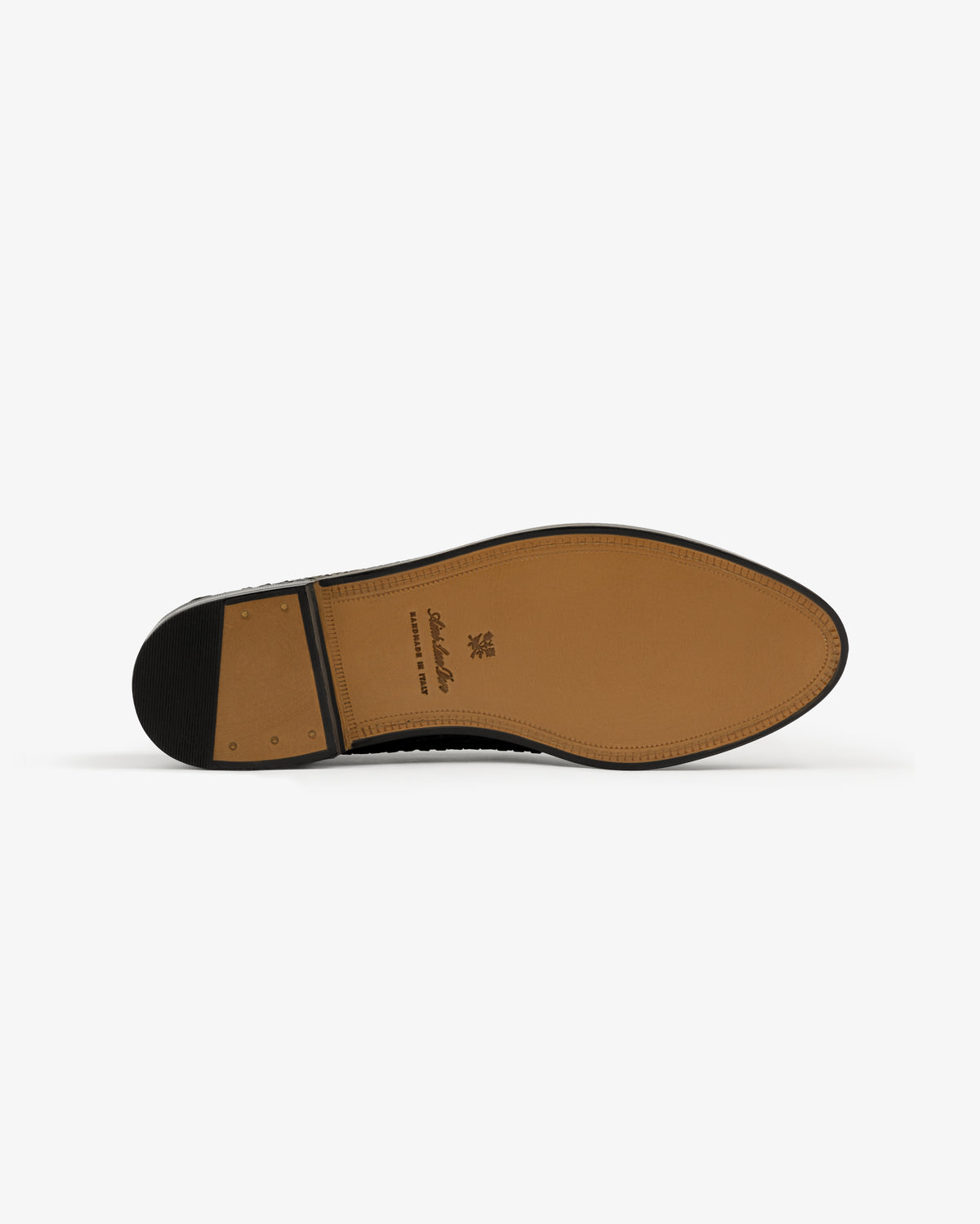 The sole of the Leather Raffia Loafer, tan leather with a black heel and stamped branding, on a white background.